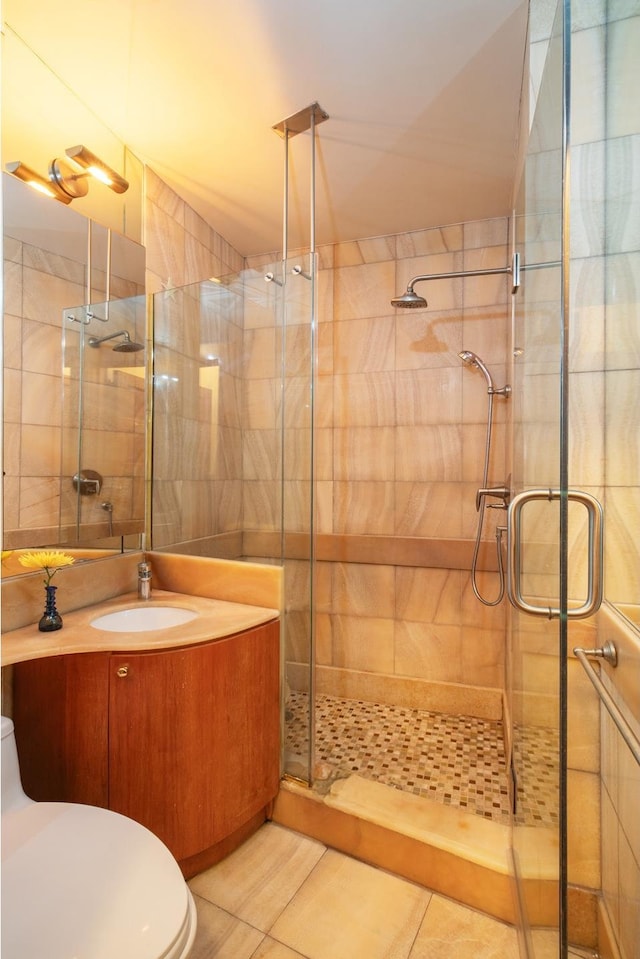 bathroom featuring a stall shower, toilet, tile patterned floors, and vanity