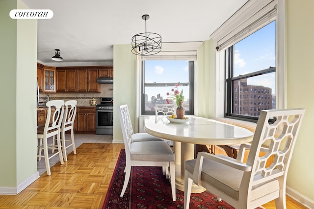 dining room featuring light parquet flooring and a notable chandelier