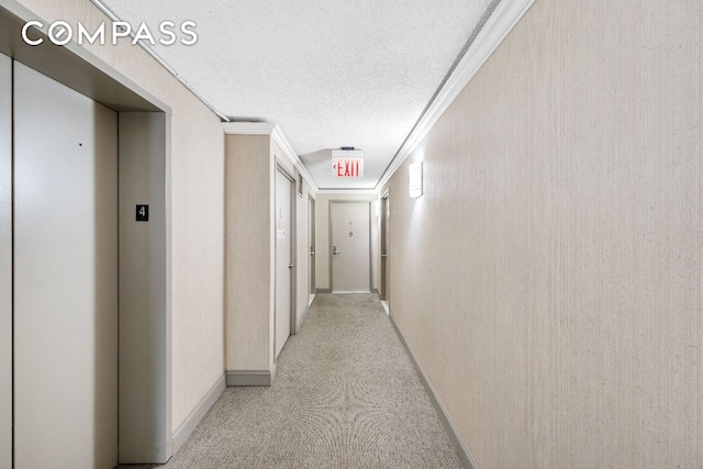 hallway with a textured ceiling, elevator, ornamental molding, and light colored carpet