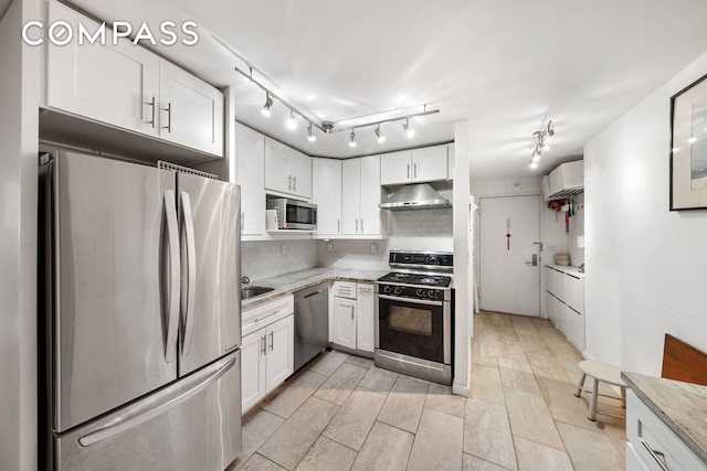kitchen featuring stainless steel appliances, under cabinet range hood, and white cabinetry