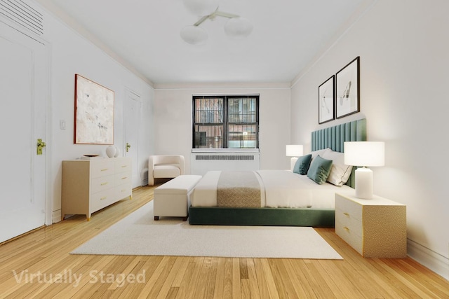 bedroom with light wood-style flooring and radiator heating unit