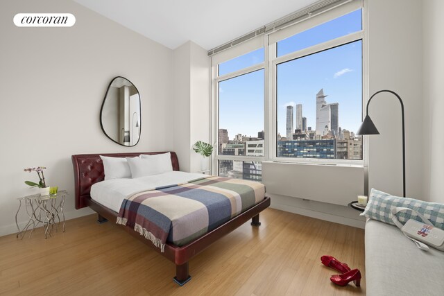 bedroom featuring multiple windows and light hardwood / wood-style flooring