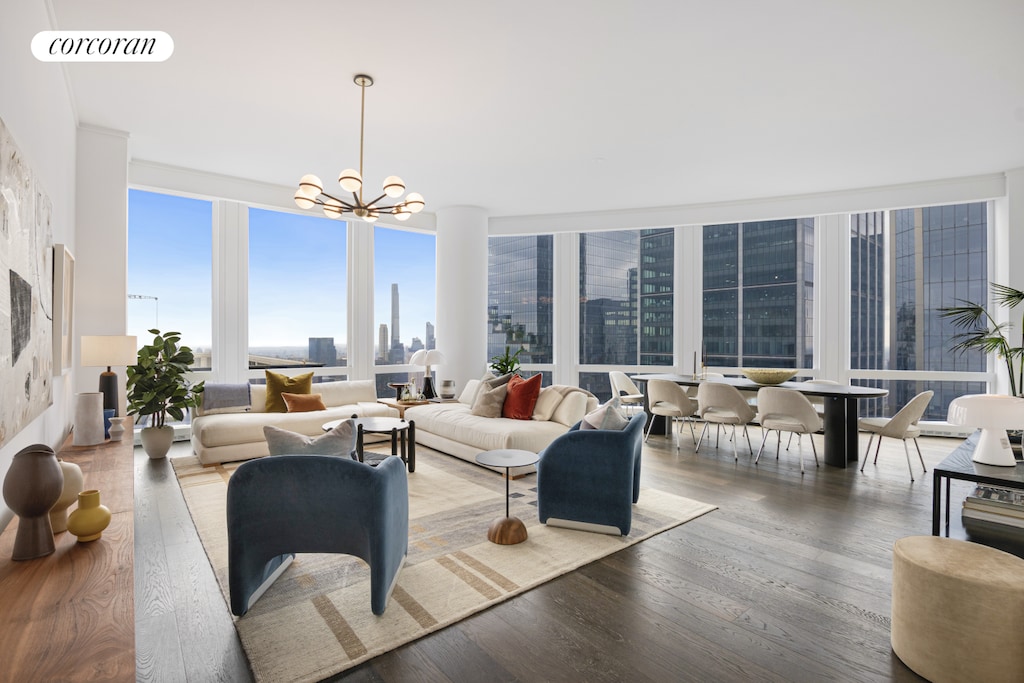 living area with a city view, wood finished floors, visible vents, and a notable chandelier