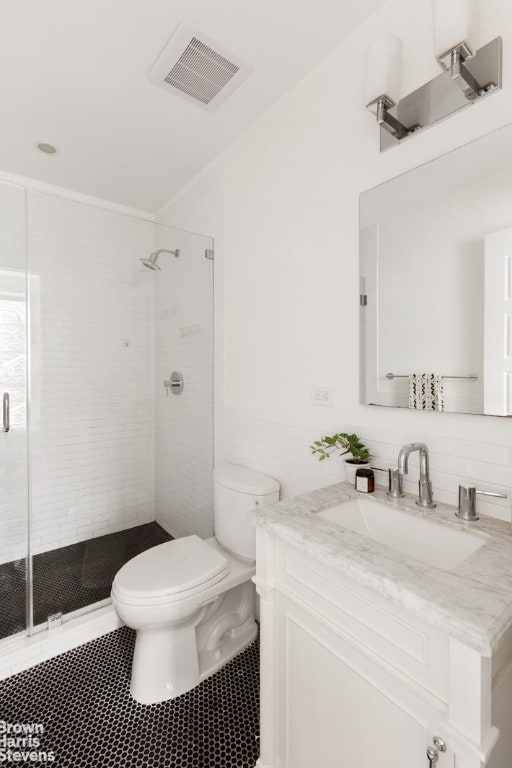 bathroom featuring toilet, vanity, tile walls, and walk in shower