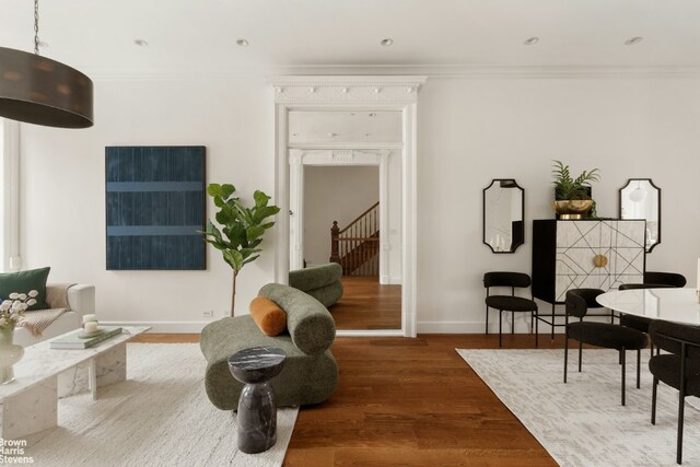 living room with wood-type flooring and ornamental molding