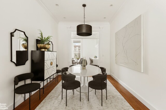 dining area featuring ornamental molding and wood-type flooring