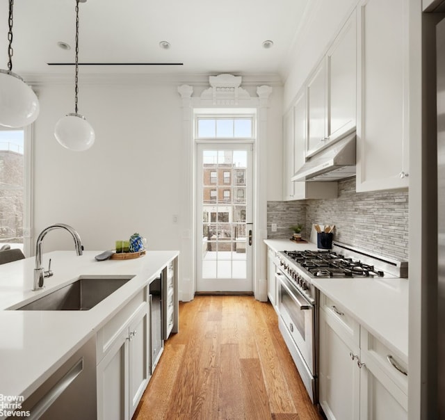 kitchen featuring decorative light fixtures, sink, stainless steel appliances, and white cabinetry