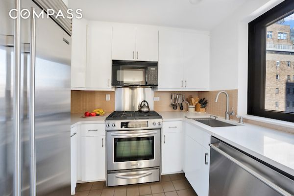 kitchen with light countertops, appliances with stainless steel finishes, a sink, and decorative backsplash