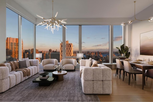 living room with a notable chandelier, wood-type flooring, and a healthy amount of sunlight