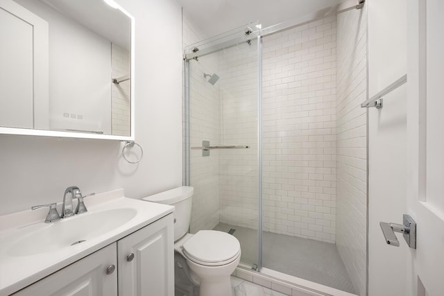 bathroom with a shower stall, toilet, and vanity