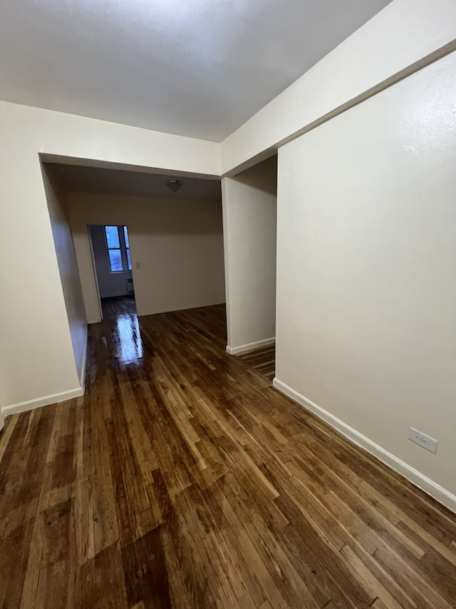 hall featuring dark wood-style floors and baseboards