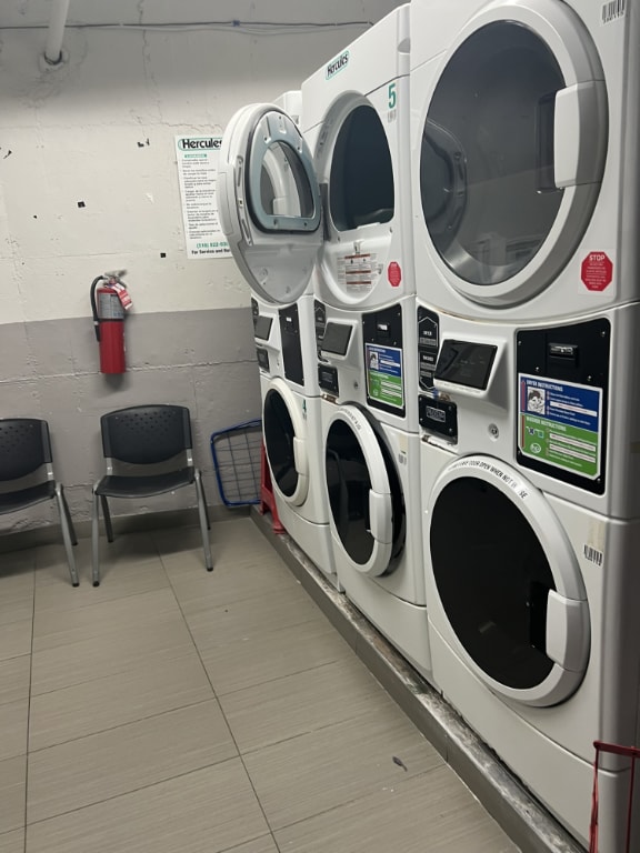 washroom featuring light tile patterned flooring and stacked washer / dryer