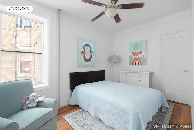 bedroom with light wood-type flooring, ceiling fan, and crown molding