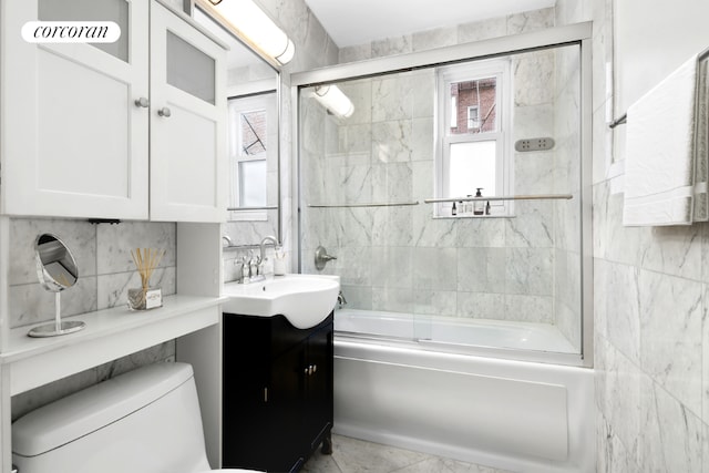 full bathroom with toilet, combined bath / shower with glass door, tasteful backsplash, tile walls, and vanity