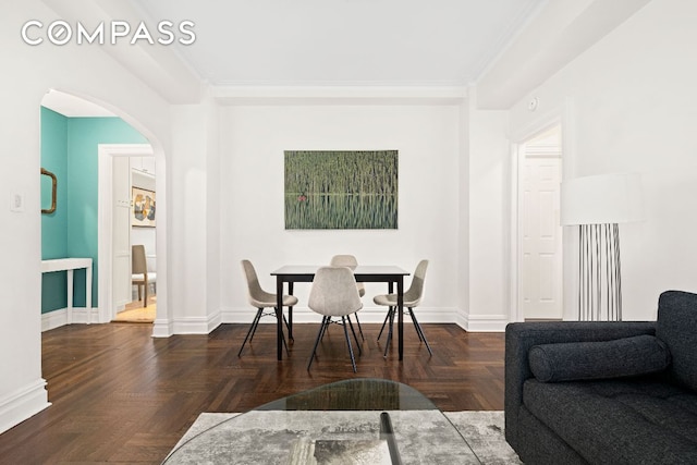 dining space with ornamental molding and dark parquet floors