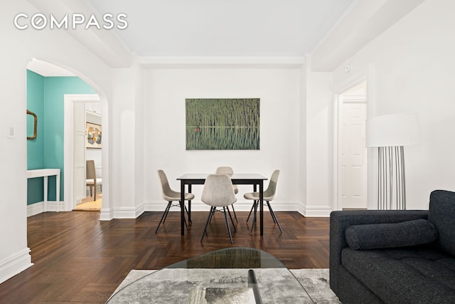 dining area featuring baseboards and arched walkways