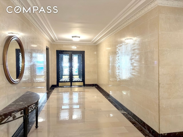 foyer entrance featuring ornamental molding, french doors, and tile walls