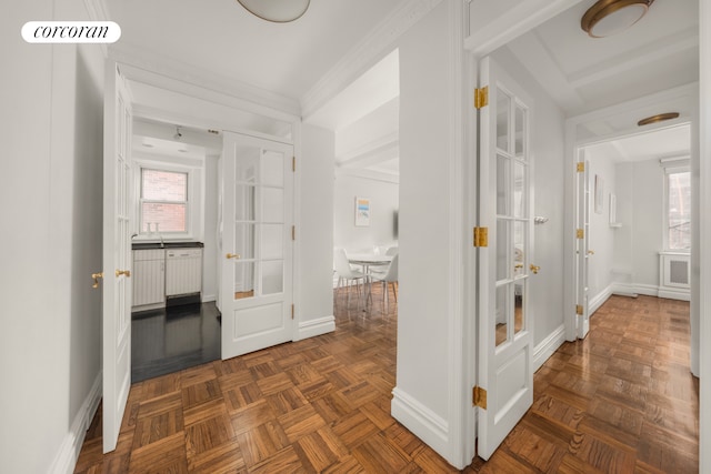 hallway featuring ornamental molding, visible vents, and baseboards