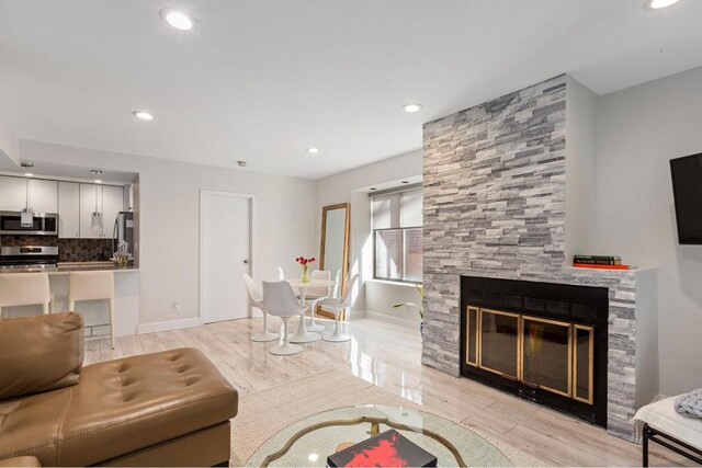 living room featuring a large fireplace and light hardwood / wood-style floors