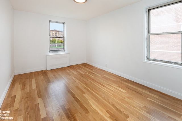 spare room with light wood-style flooring and baseboards