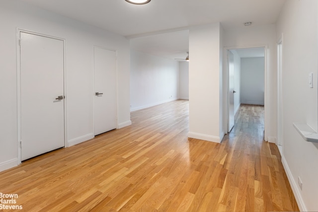 empty room with light wood-type flooring and baseboards