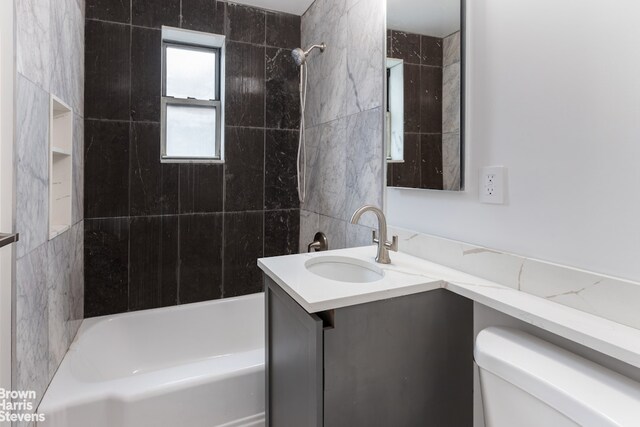 bathroom with bathing tub / shower combination, vanity, and toilet