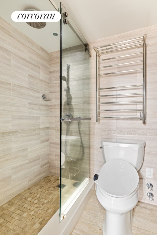 bathroom featuring toilet, tiled shower, tile patterned flooring, tile walls, and radiator heating unit