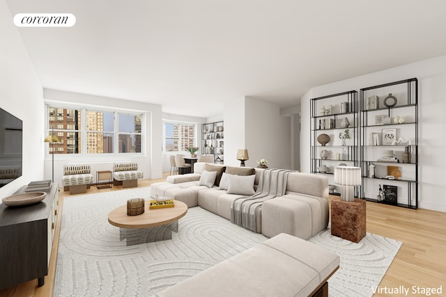 living area featuring visible vents, baseboards, and wood finished floors