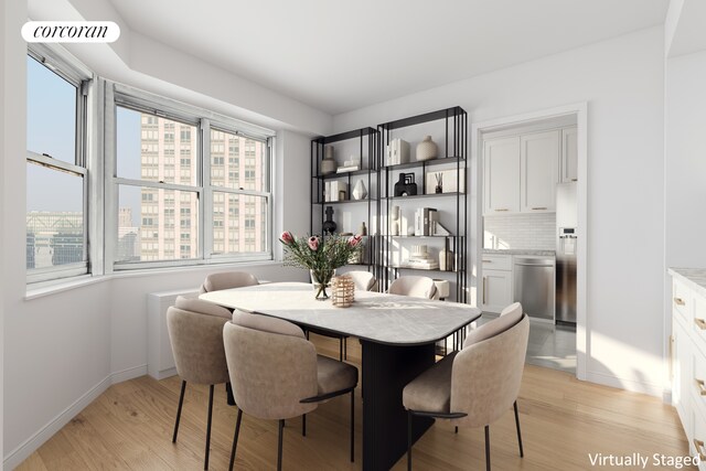 dining space featuring light wood-type flooring, visible vents, and baseboards