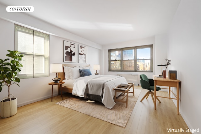 bedroom with multiple windows, wood finished floors, visible vents, and baseboards