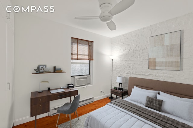 bedroom featuring wood finished floors, cooling unit, ceiling fan, a desk, and baseboards