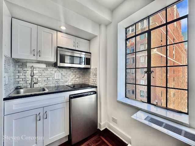 kitchen with sink, backsplash, dishwasher, and white cabinets