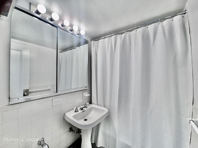 full bathroom with curtained shower, backsplash, and tile walls