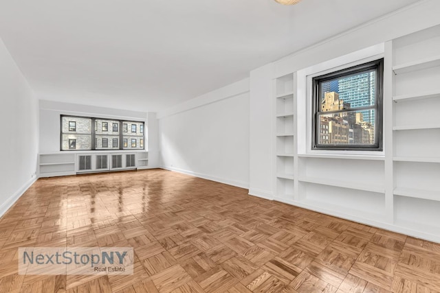 unfurnished living room featuring radiator, baseboards, and built in shelves