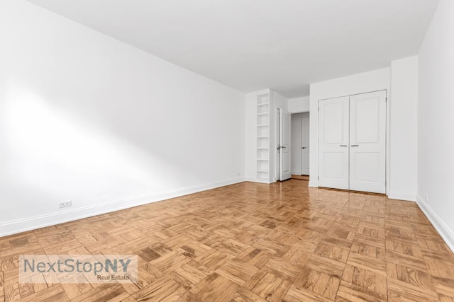 unfurnished bedroom featuring a closet and light parquet floors