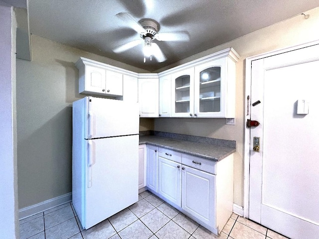 kitchen featuring white fridge, ceiling fan, light tile patterned flooring, and white cabinets