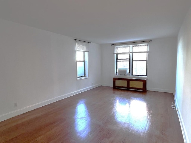 spare room featuring cooling unit and dark hardwood / wood-style flooring