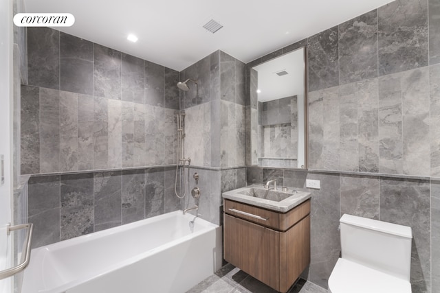 208 Delancey St Unit 1A, New York City, NY 10002 - full bathroom with tile walls, shower / tub combination, toilet, vanity, and recessed lighting