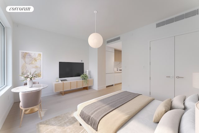 bedroom with visible vents, light wood-style flooring, and baseboards