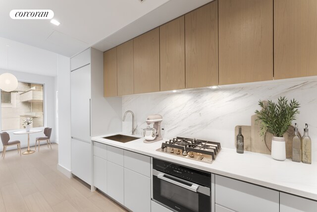 kitchen featuring visible vents, a sink, oven, light countertops, and stainless steel gas stovetop