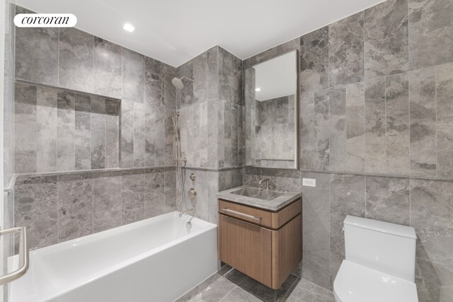 full bath featuring toilet, recessed lighting, tile walls, washtub / shower combination, and vanity