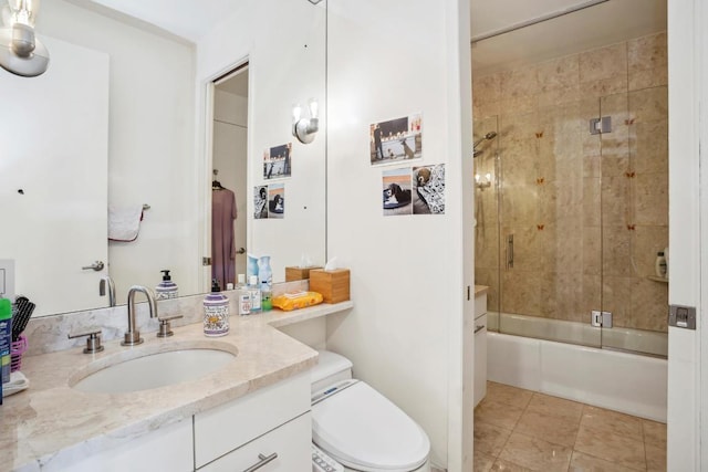 bathroom featuring tile patterned flooring, vanity, toilet, and bath / shower combo with glass door