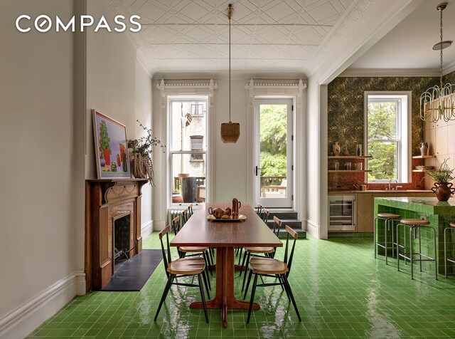 234 Clinton St, New York City, NY 11201 - dining area featuring beverage cooler, healthy amount of natural light, baseboards, a fireplace, and crown molding