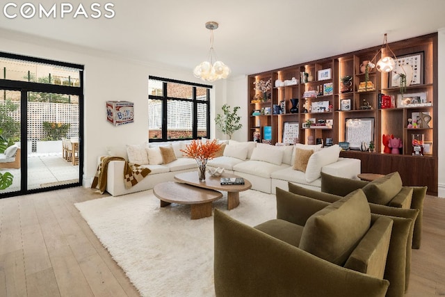 living room featuring a notable chandelier and light wood-type flooring