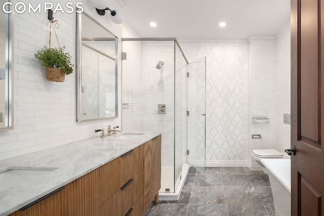 bathroom with vanity, toilet, an enclosed shower, and tile walls