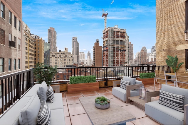 view of patio / terrace featuring a skyline view, outdoor lounge area, a balcony, and a wall mounted air conditioner