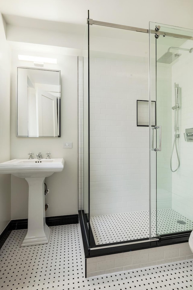 full bath with baseboards and a shower stall