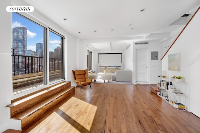 living area featuring beam ceiling and hardwood / wood-style flooring