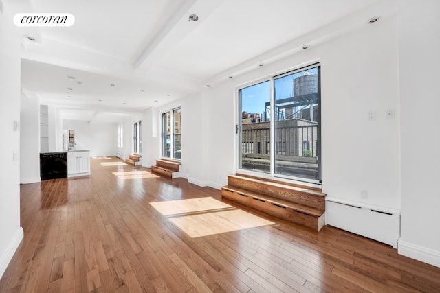 interior space featuring a baseboard radiator, hardwood / wood-style floors, and beam ceiling