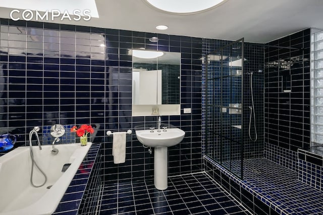 bathroom featuring shower with separate bathtub, tile walls, and tile patterned floors